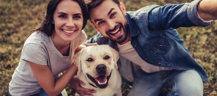 Couple taking a selfie with their dog