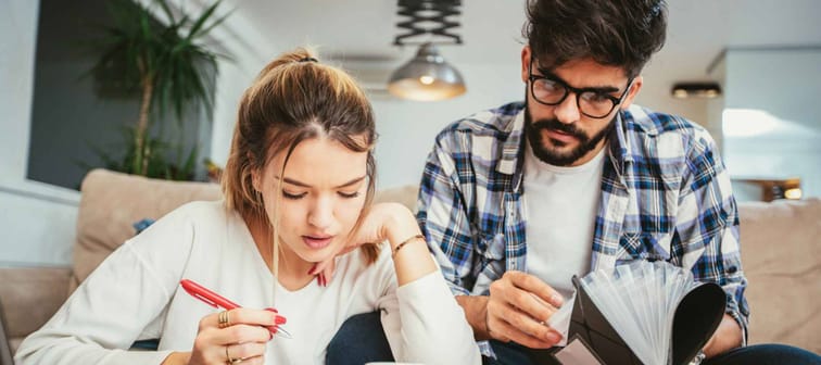 Woman and man doing paperwork together, sitting on a couch