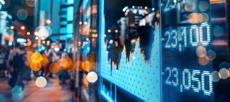 Display of Stock market quotes with city scene reflect on glass