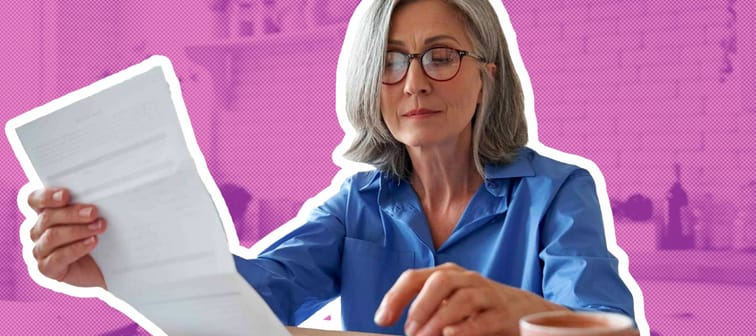 Senior mature business woman holding paper bill using calculator.