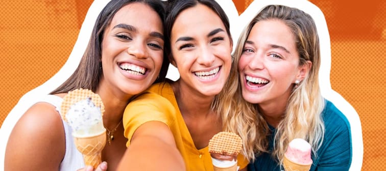Laughing girls eating ice cream cones smile for the camera.
