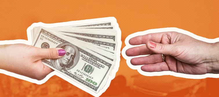 Macro focus on female hands with dollar upon crashed car