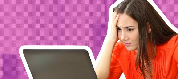 Sad and worried entrepreneur working on line with a laptop in an office desk or home