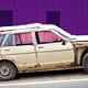 old car in front of pink building