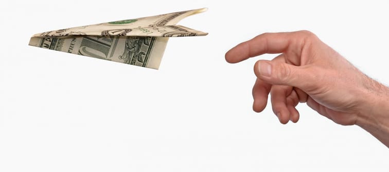 Investment concept.Hand throwing a dollar paper plane isolated on white background.