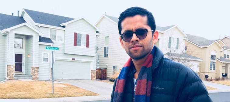 Stylish young man standing in residential neighborhood