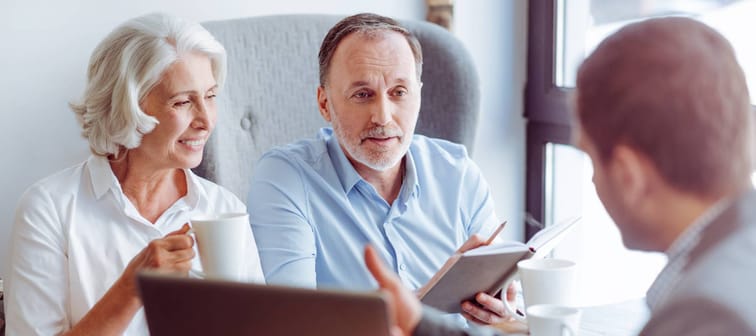 Positive aged couple consulting with insurance agent
