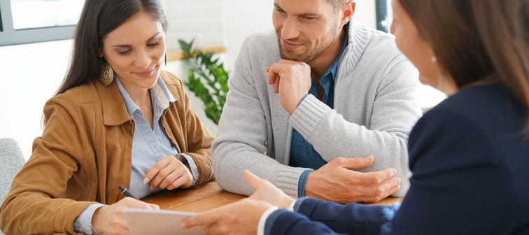 Couple meeting financial adviser for home investment contract