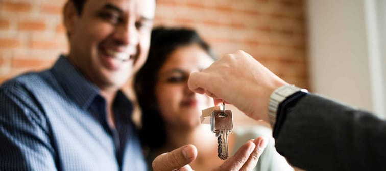 Cheerful couple with keys to their new home